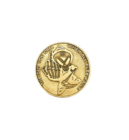 Brass challenge coin with figure engraving on a light background