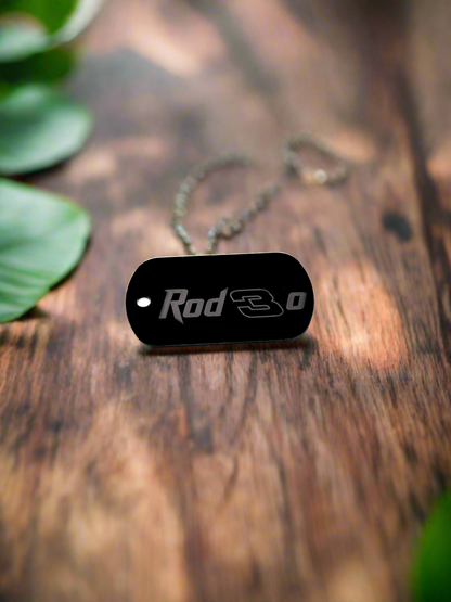 Black engraved dog tag keychain on weathered wood