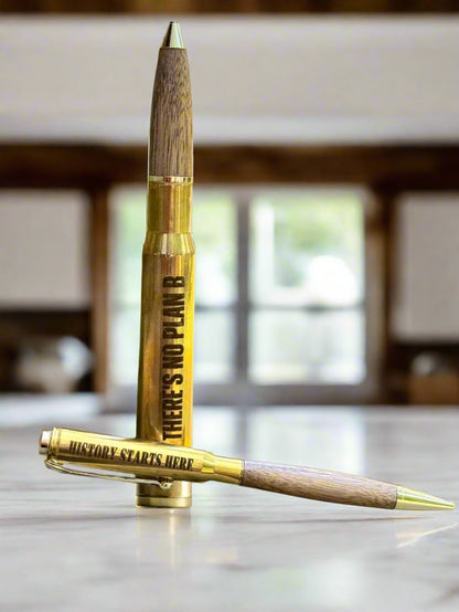Brass and walnut bullet pens resting on a marble surface