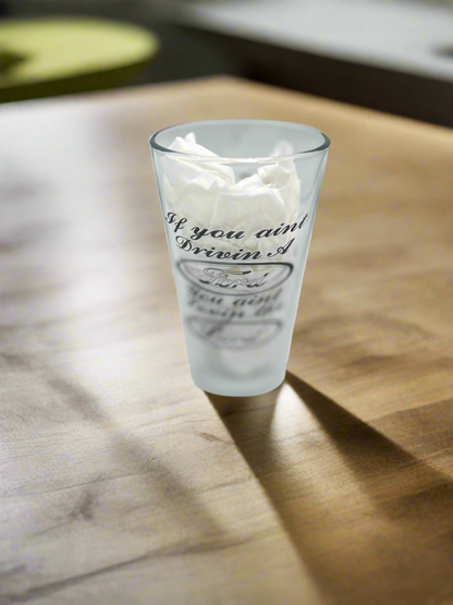 Engraved beer glass on a wood counter in natural light