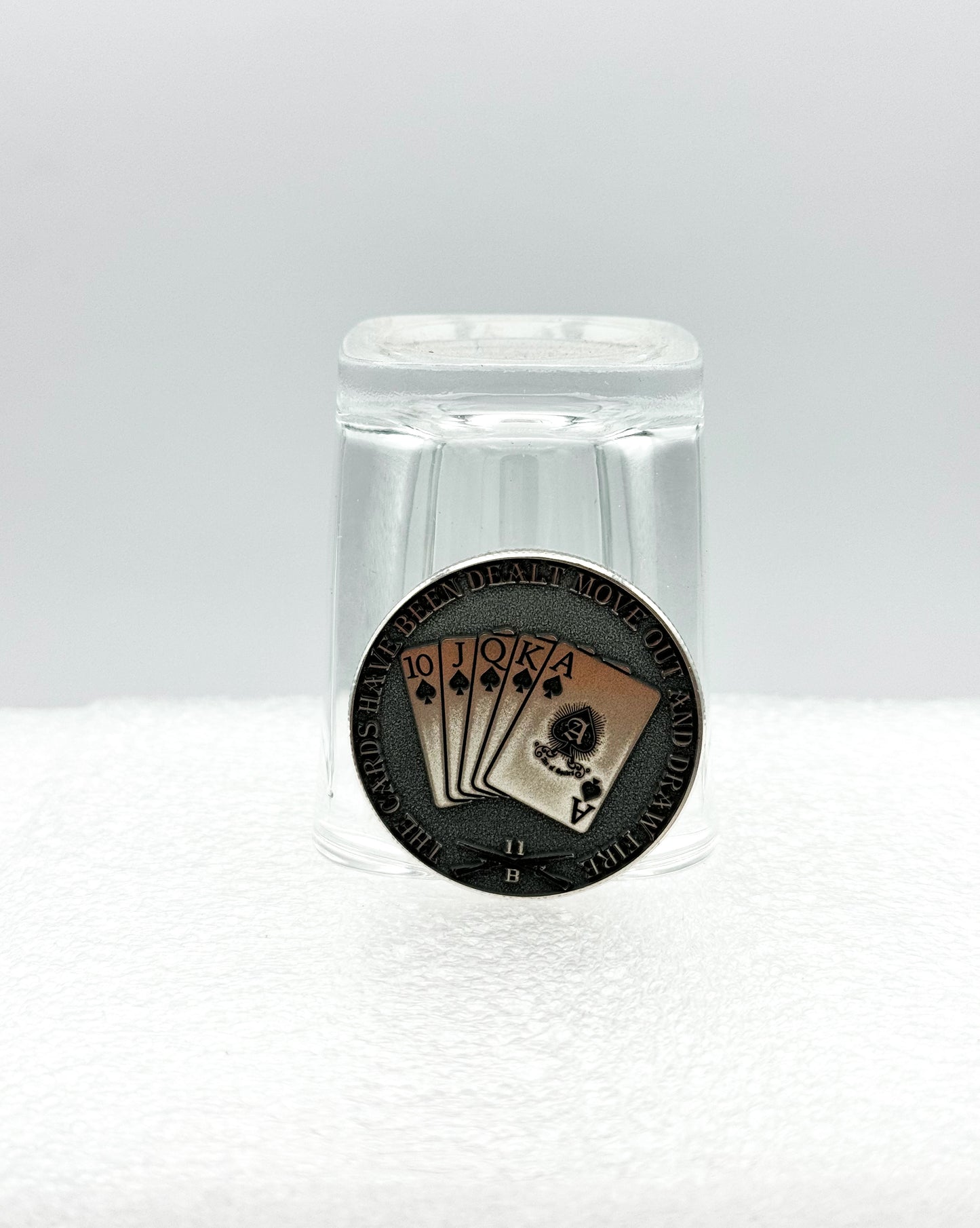 Engraved coin displayed with a shot glass