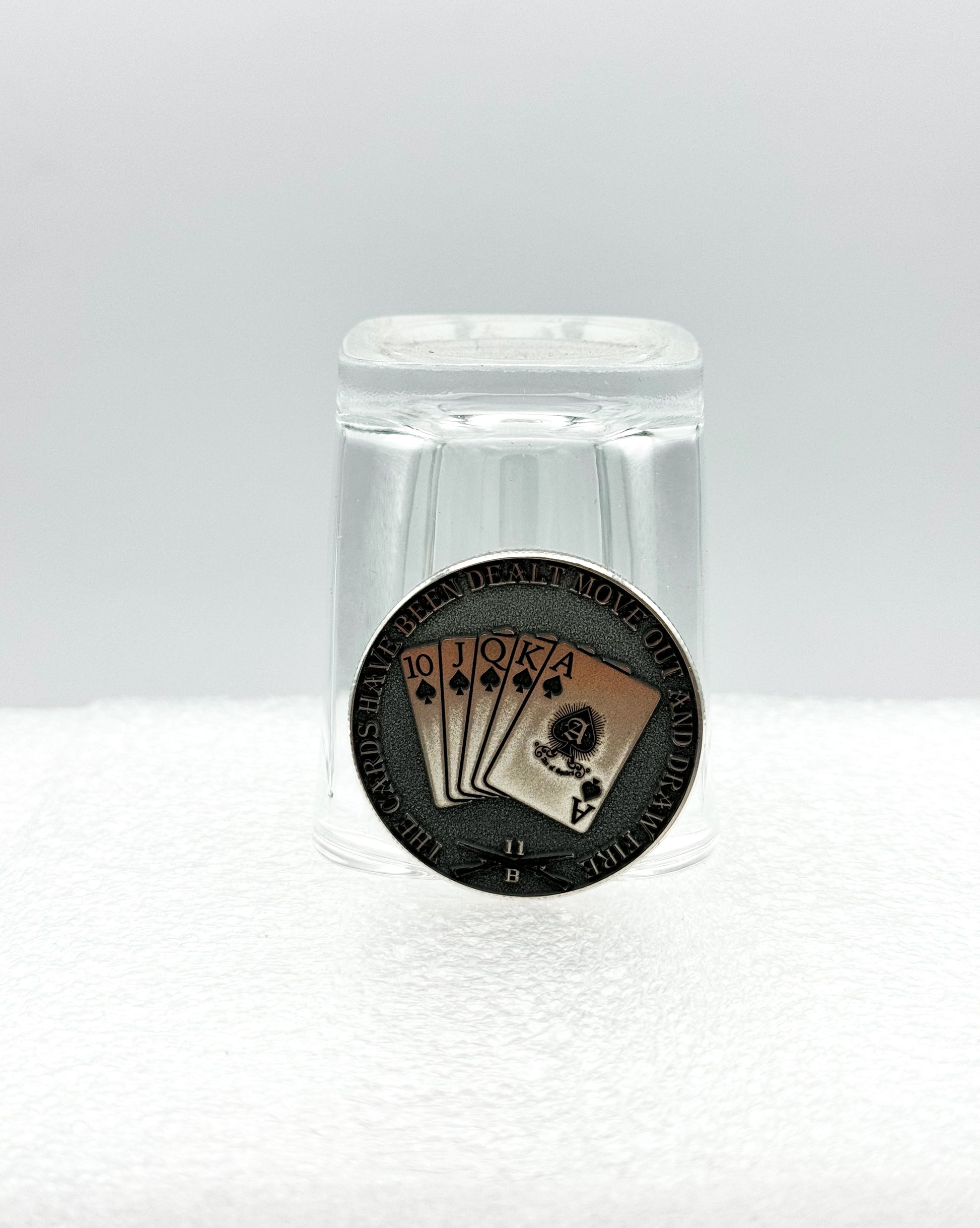 Engraved coin displayed with a shot glass
