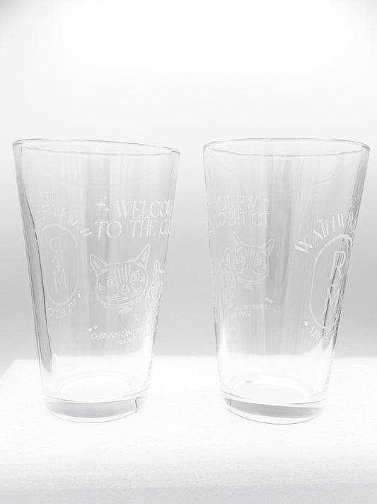Two engraved pint glasses side by side on a white background