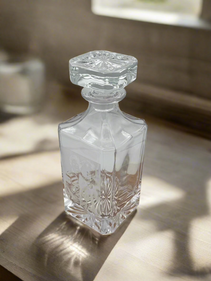Empty engraved glass decanter with fitted stopper, side view