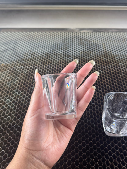 Blank square shot glass held over the laser bed showing size